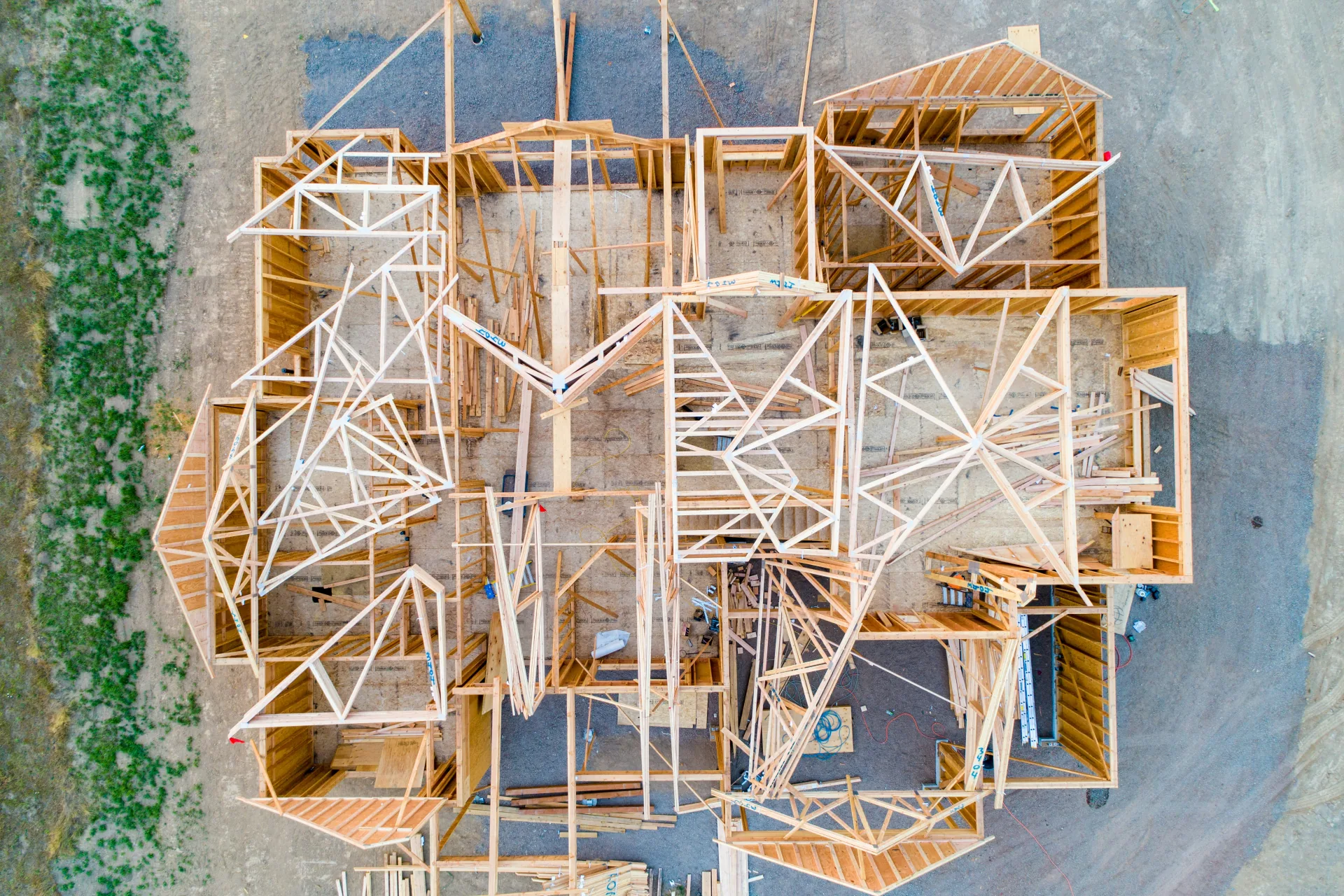 Residential construction site showing wood framing and roof trusses during a BC Step Code 4 compliant new home build